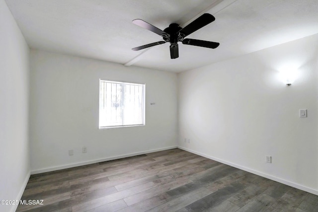 spare room with baseboards, ceiling fan, and wood finished floors