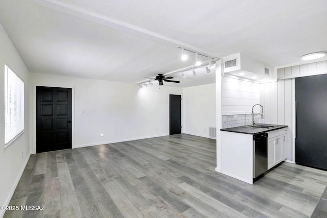 kitchen featuring dark countertops, a sink, dishwasher, a ceiling fan, and white cabinetry