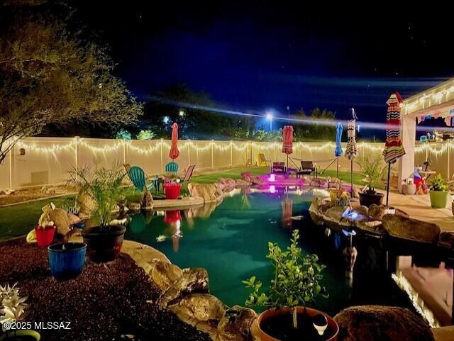 33925 S Alvarado St, Red Rock, AZ 85145 - pool at night with a fenced in pool and a fenced backyard