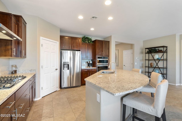 7084 W Cliff Spring Trl, Marana, AZ 85658 - kitchen featuring appliances with stainless steel finishes, a sink, a center island with sink, a breakfast bar area, and recessed lighting
