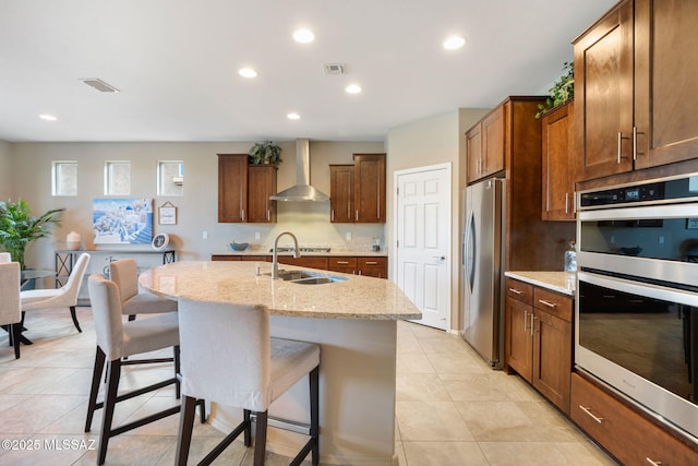 7084 W Cliff Spring Trl, Marana, AZ 85658 - kitchen with wall chimney range hood, stainless steel appliances, a sink, a breakfast bar area, and light tile patterned floors