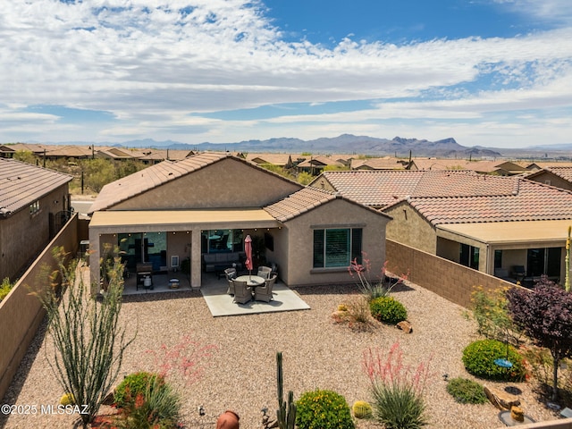 7084 W Cliff Spring Trl, Marana, AZ 85658 - rear view of house with stucco siding, a mountain view, a fenced backyard, and a patio