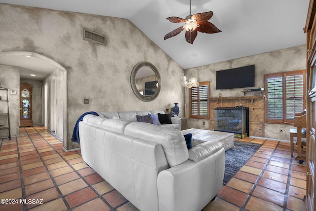 living area with a ceiling fan, visible vents, plenty of natural light, and vaulted ceiling