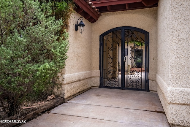 entrance to property with a gate and stucco siding