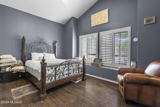 bedroom with baseboards, a textured wall, wood finished floors, and lofted ceiling