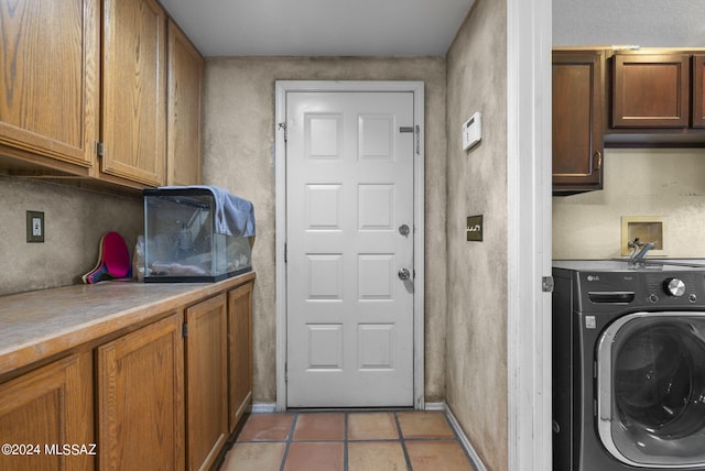 clothes washing area featuring baseboards, cabinet space, washer / clothes dryer, and light tile patterned flooring