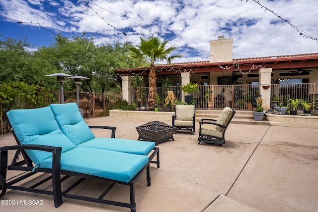view of patio / terrace featuring fence and an outdoor living space with a fire pit