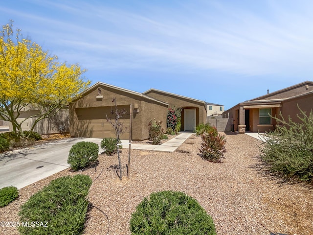 ranch-style home with fence, an attached garage, stucco siding, and concrete driveway