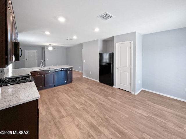kitchen featuring visible vents, dark brown cabinets, baseboards, a sink, and black appliances