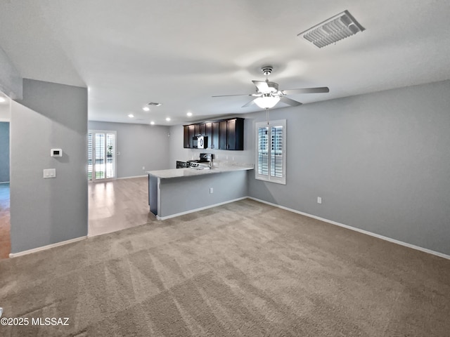 interior space featuring light countertops, baseboards, light carpet, and visible vents
