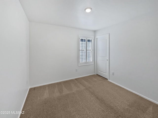 empty room featuring baseboards and carpet