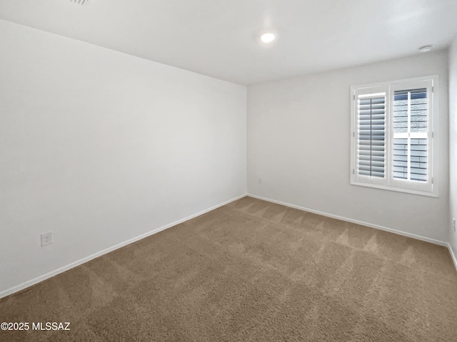 carpeted spare room with baseboards