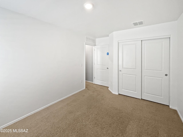 unfurnished bedroom featuring visible vents, carpet flooring, baseboards, and a closet