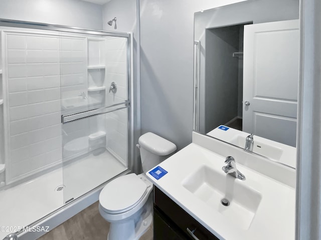 full bath featuring vanity, wood finished floors, toilet, and a shower stall