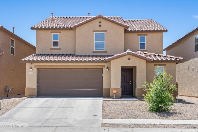 mediterranean / spanish house featuring a tiled roof, stucco siding, concrete driveway, and a garage