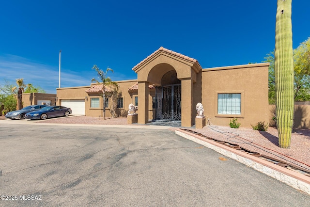 1330 W Panorama Rd, Tucson, AZ 85704 - view of front facade with an attached garage, stucco siding, a tiled roof, and driveway