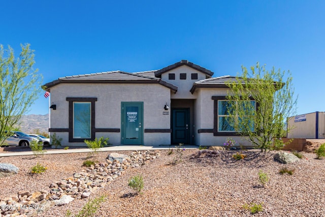 prairie-style home with stucco siding and a tile roof