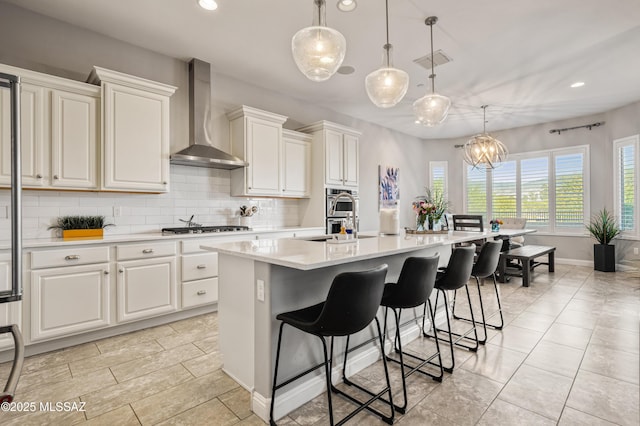 kitchen featuring light countertops, tasteful backsplash, recessed lighting, and wall chimney exhaust hood