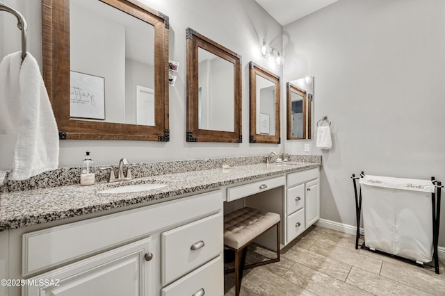 bathroom with a sink, baseboards, tile patterned flooring, and double vanity