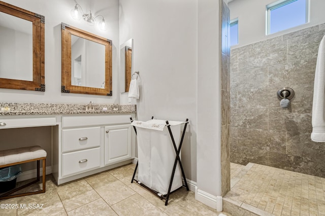 bathroom with tile patterned floors, walk in shower, and vanity