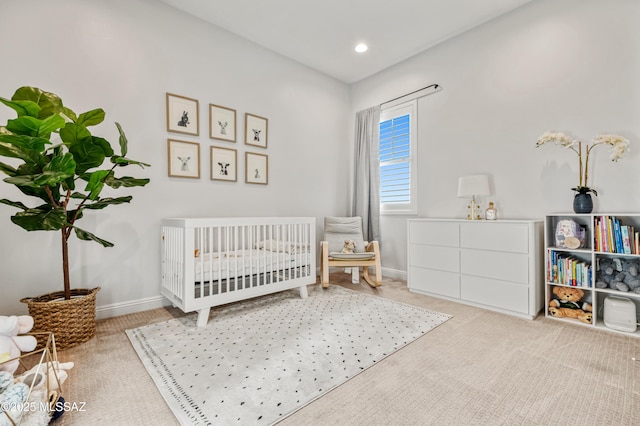 carpeted bedroom featuring recessed lighting, baseboards, and a nursery area
