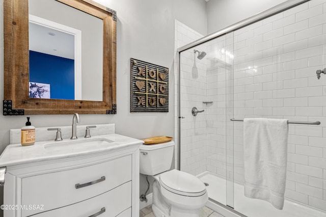 bathroom featuring vanity, toilet, and a shower stall