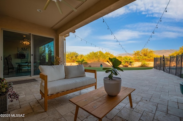 view of patio / terrace featuring an outdoor living space, a ceiling fan, and a fenced backyard