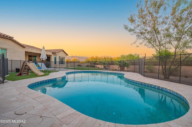 pool at dusk featuring a fenced in pool, a patio, and a fenced backyard