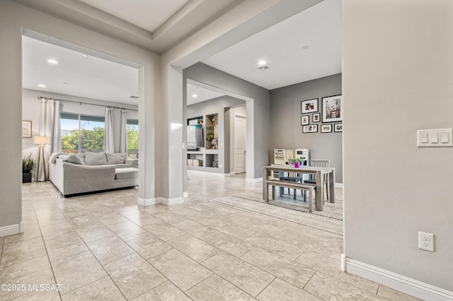 hall with recessed lighting, baseboards, and light tile patterned flooring