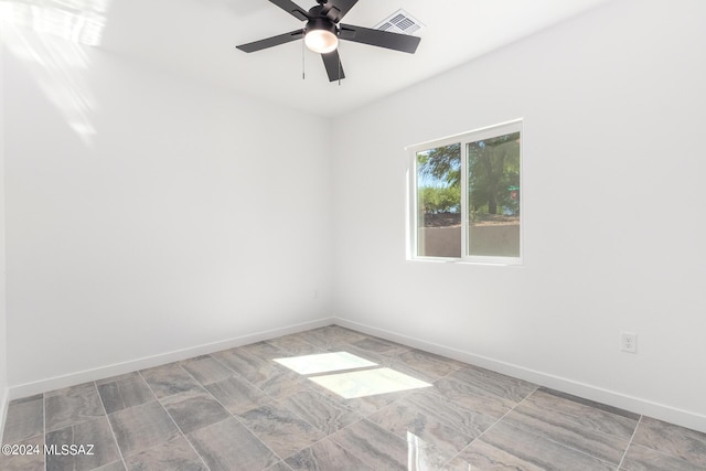 spare room with ceiling fan, visible vents, and baseboards