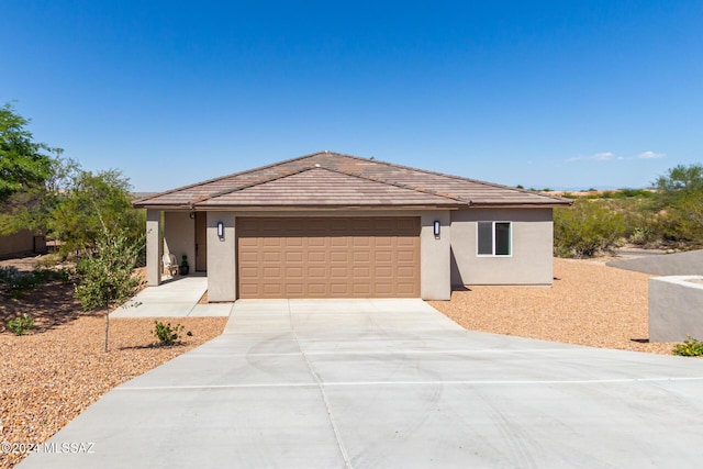 single story home featuring concrete driveway, a garage, and stucco siding