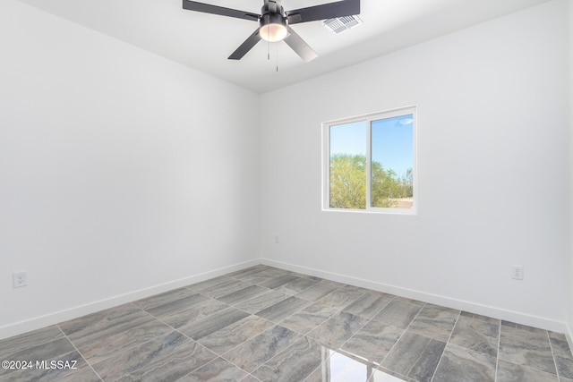 empty room with baseboards, visible vents, and ceiling fan