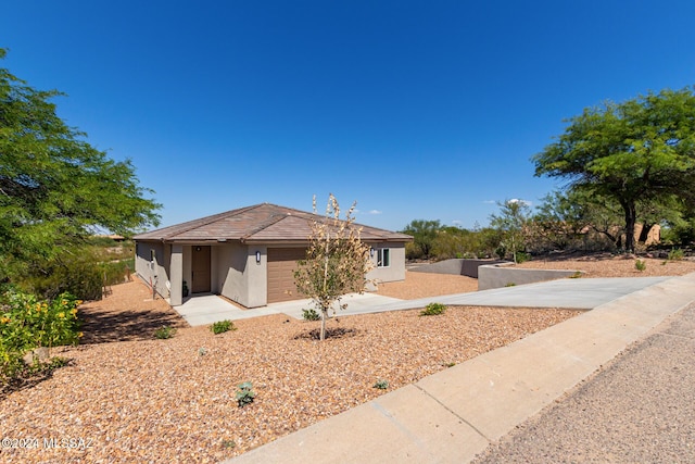 ranch-style house with a garage, stucco siding, and driveway