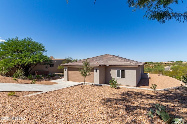 single story home with a garage, driveway, and stucco siding