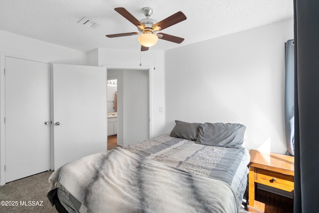 carpeted bedroom featuring ceiling fan, a textured ceiling, and visible vents