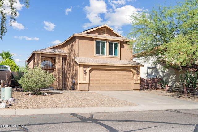 traditional home with concrete driveway, an attached garage, fence, and stucco siding