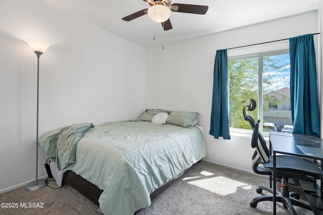 carpeted bedroom featuring baseboards, a ceiling fan, and a textured ceiling