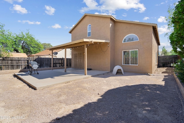 back of property featuring a fenced backyard, stucco siding, and a patio area
