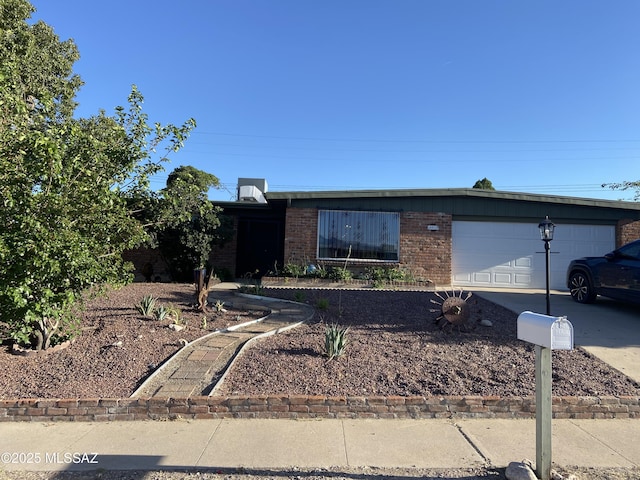 single story home with brick siding, an attached garage, and driveway