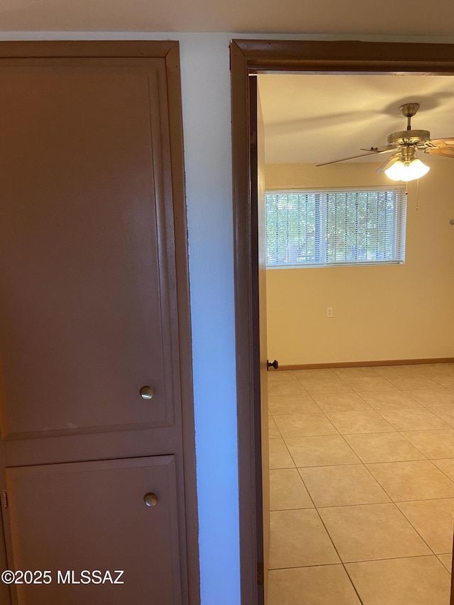 hallway with baseboards and light tile patterned floors