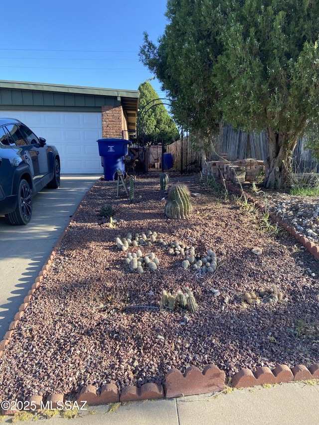 exterior space with an attached garage, fence, and driveway