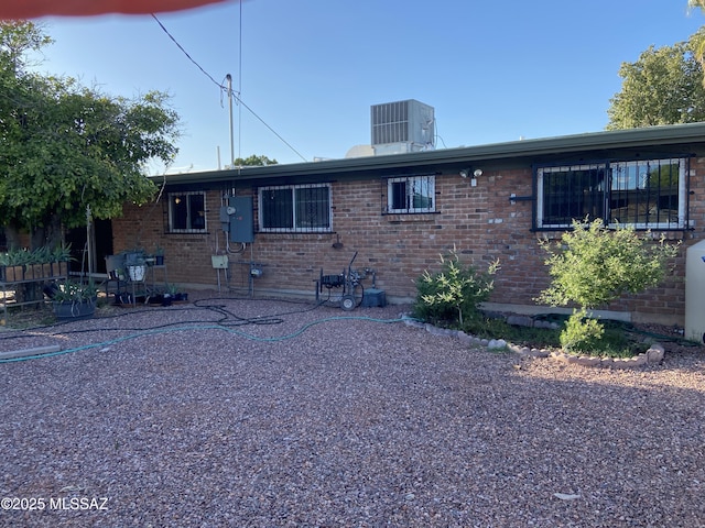 rear view of property featuring a patio, cooling unit, and brick siding