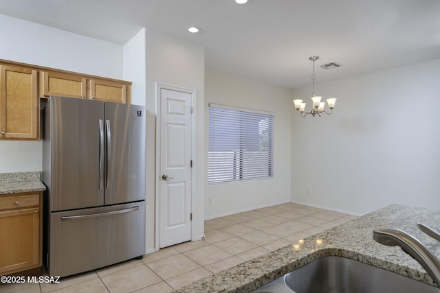 kitchen with hanging light fixtures, an inviting chandelier, freestanding refrigerator, light tile patterned floors, and visible vents