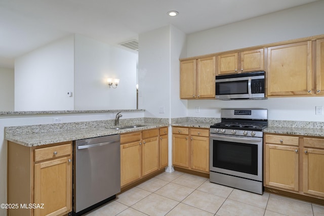 kitchen featuring a sink, light tile patterned floors, stainless steel appliances, and a peninsula