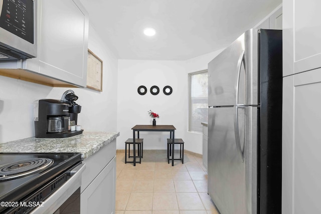 5675 N Camino Esplendora Unit 1103, Tucson, AZ 85718 - kitchen featuring appliances with stainless steel finishes, light tile patterned floors, light stone counters, and white cabinets