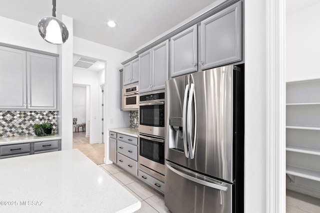 kitchen with light countertops, stainless steel appliances, and gray cabinetry