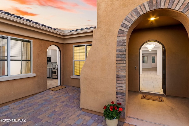 entrance to property with a patio area and stucco siding
