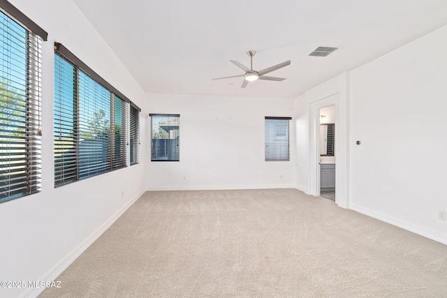 empty room featuring baseboards, a ceiling fan, carpet flooring, and visible vents