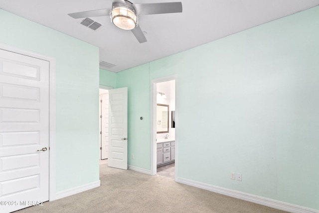 unfurnished bedroom with ceiling fan, light carpet, baseboards, ensuite bathroom, and visible vents