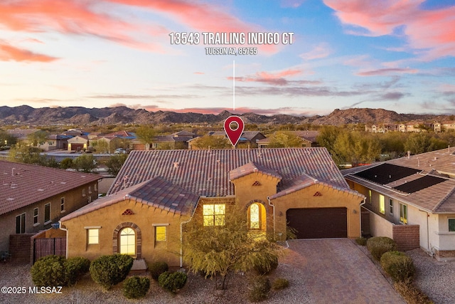 mediterranean / spanish-style home with fence, a mountain view, an attached garage, and stucco siding